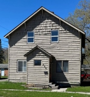 Picture of the front of a light brown, two story house.